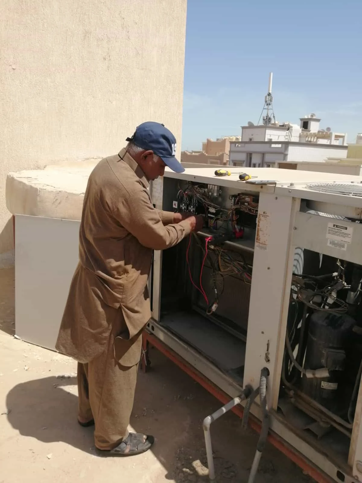 فني يفحص تشغيل وحدة تكييف