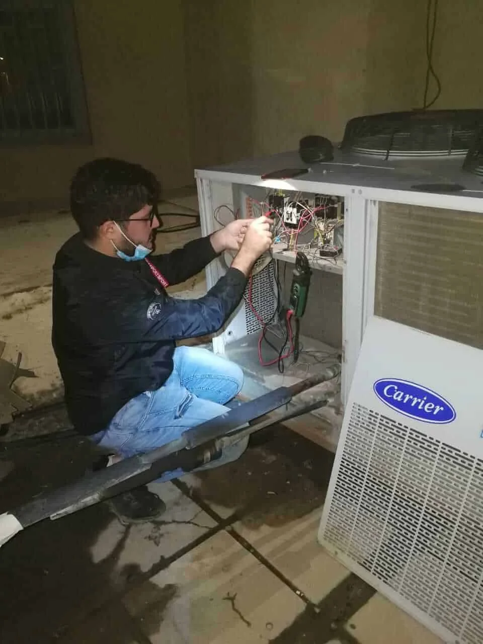 فني تكييف أثناء فحص واستبدال قطع غيار المكيف